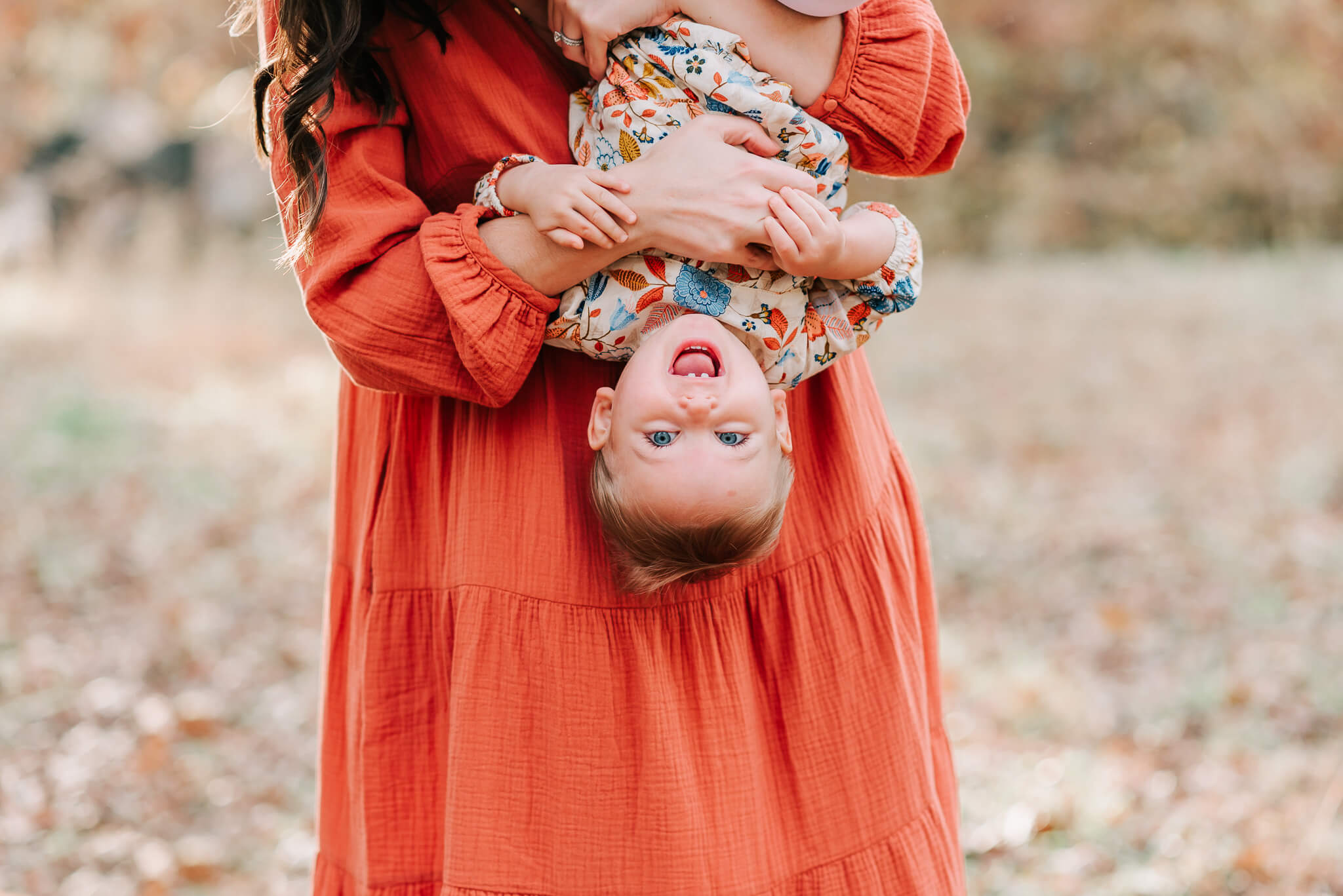 A child in floral dress being held upside-down by her mother, things to do in northern va with kids