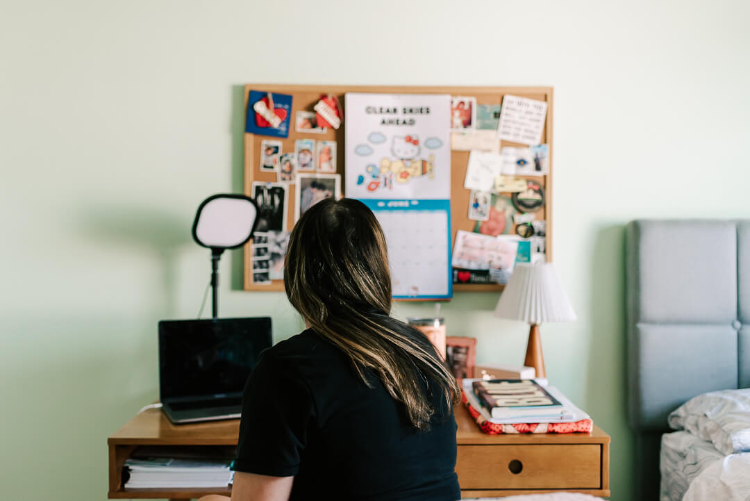 woman wearing black shirt looking up at her bulletin board in her home office