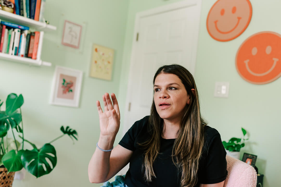 caucasian woman wearing black gesturing about maternal mental health in her office